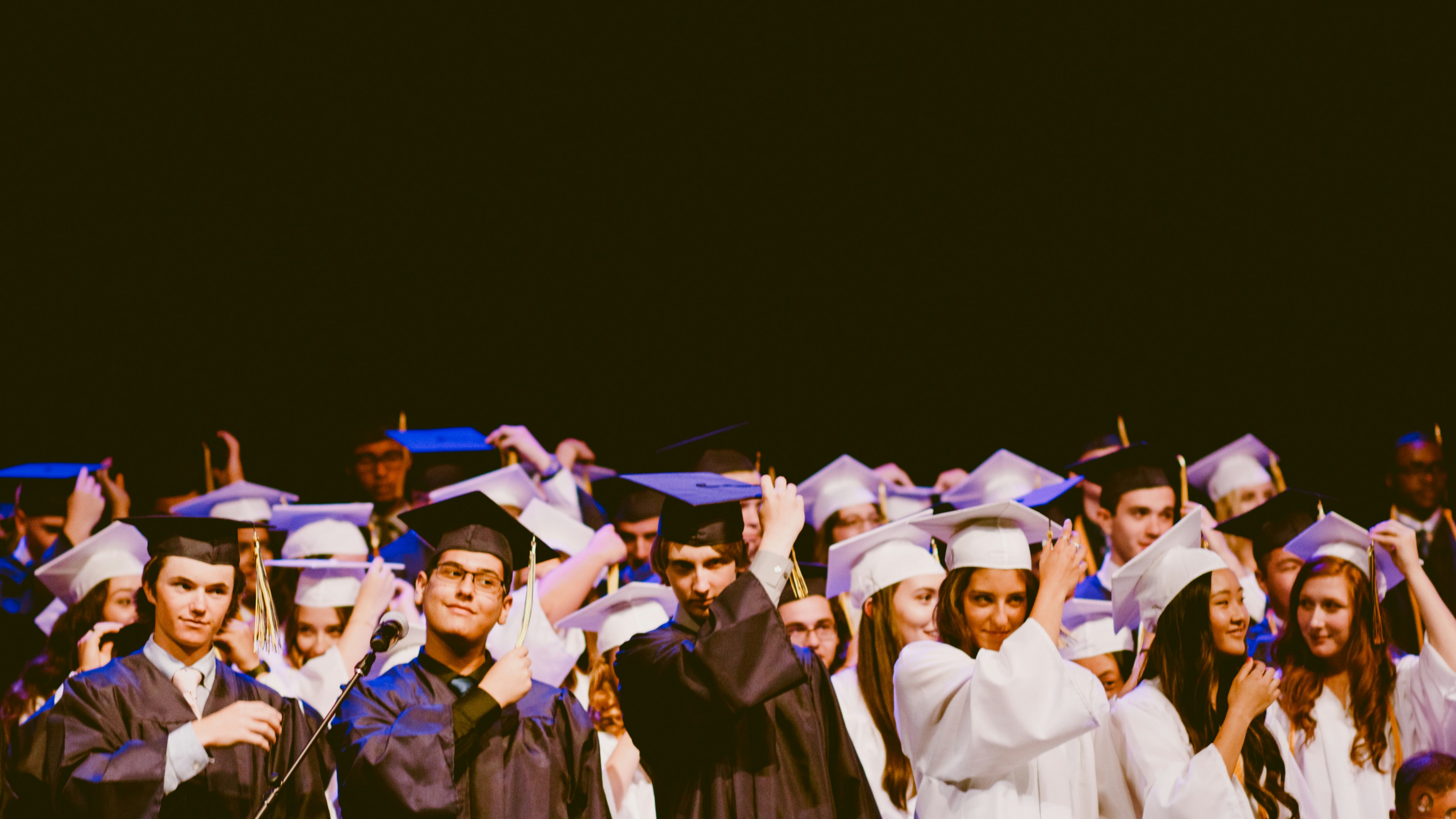 A group of students smiling and celebrating their graduation.